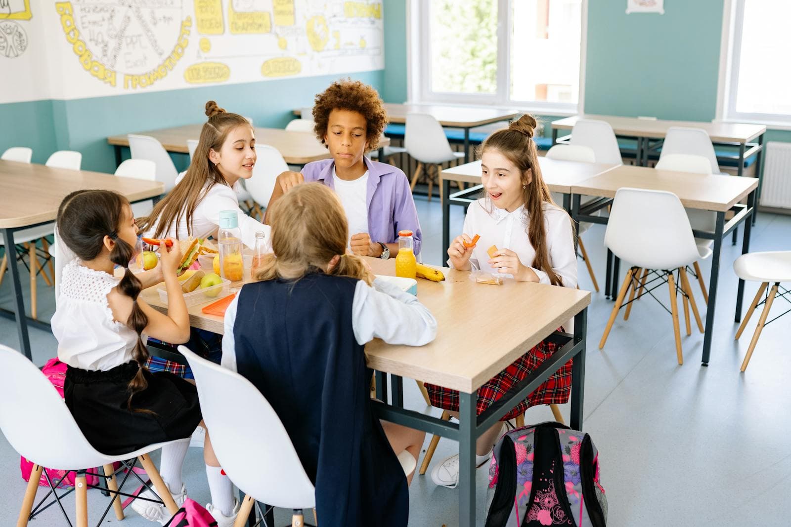 Cooks serving hot lunch to students in a school kitchen